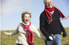 senior couple running through field